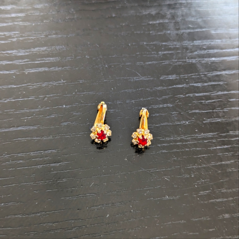 Gold tone clip-on earrings with red gem